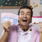 Una persona sostiene varios boletos de lotería abiertos en abanico